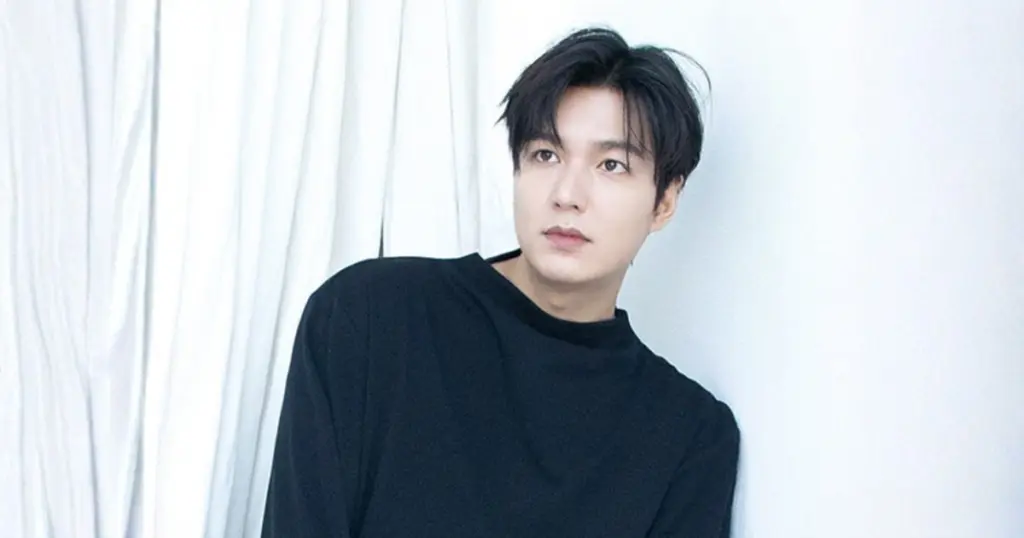 Retrato do ator sul-coreano Lee Min-ho vestindo um suéter preto de gola redonda, olhando pensativamente para o lado, adequado para uma biografia.